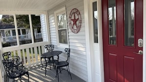 A porch with a red door, white railings, and a star-shaped decoration. - Charming Cottage with Pool. Close to shops, restaurants and farms (West Cape May)