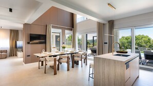 Eine moderne Küche mit Essbereich, großen Fenstern und Blick ins Freie.
