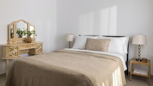 Une chambre à coucher avec un lit, des tables de chevet, une commode et un miroir.