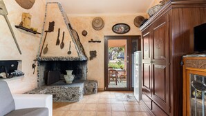 Una sala de estar acogedora con chimenea de piedra, armarios de madera y un televisor.