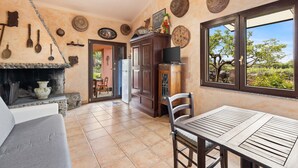 Una cocina con chimenea de piedra, armarios de madera y una mesa de comedor con sillas.