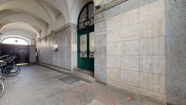 A hallway with a green door, stone walls, and a bicycle parked to the left. - AS HOME Rynek 265 (Wrocław)