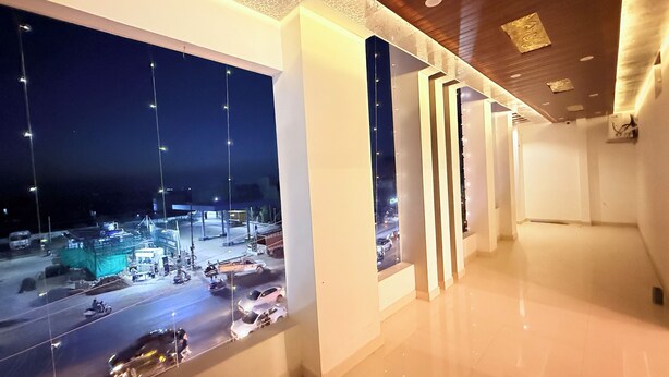 A hallway with a view of a parking lot at night.