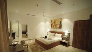 Un dormitorio moderno con una cama grande, mesitas de noche, un espejo y un cuadro en la pared.
