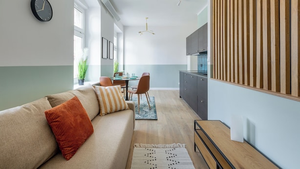 Een moderne woonkamer met een bank, een eethoek en een keuken.