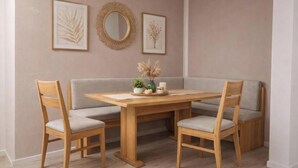 Ein Essbereich mit Holztisch, vier Stühlen, einer Bank und Wandbildern.