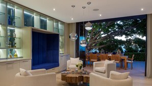 Una sala de estar moderna con zona de estar, una mesa de centro y un comedor con muebles de madera.