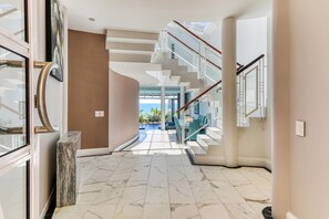 A modern interior with a marble floor, a staircase, and a view to the outside. - Camps Bay 6bed w Ocean Views and Pool Villa Sevara (Cape Town)