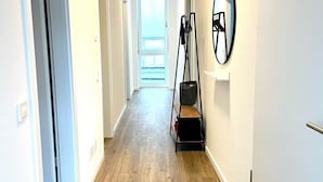 A hallway with wooden flooring, white walls, and a door at the end. - VetterLux Bellevue, suite, citycenter Ravensburg (Ravensburg)