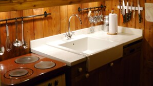 Une cuisine avec des meubles en bois, un évier à deux bacs et une cuisinière.