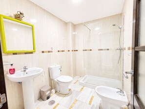 Un baño moderno con lavamanos, inodoro, bañera y ducha.