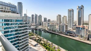 A high-rise hotel with multiple floors, a marina with boats, and a river. - Free Housekeeping Visits During Your Stay - Stayshort - Elegant 2 Bedroom in Dubai Marina That Sleeps 4 (Dubai)