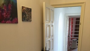 Un couloir avec un lit, une porte et un radiateur.