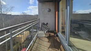 A balcony with a wooden floor, metal railing, and a glass door. - Edinburgh 1BR Apt with Balcony & Lift (Edinburgh)
