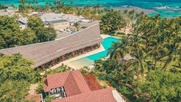 A resort with a large pool, palm trees, and a view of the ocean.