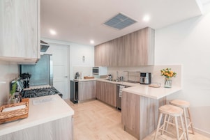Una cocina moderna con una isla central, electrodomésticos de acero inoxidable y armarios de madera.