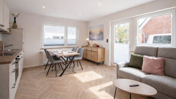 Una cocina moderna con una mesa de comedor, un sofá y una pequeña mesa de centro.