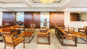 Een modern interieur met houten meubels, een groot raam en uitzicht op zee.