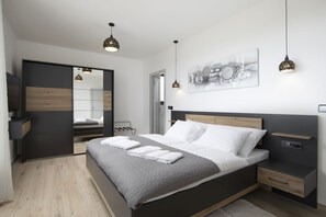 A modern bedroom with a bed, bedside tables, a wardrobe, and a mirror. - Villa Leola in Ližnjan (Ližnjan)