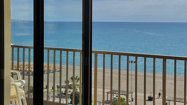 Ein Balkon mit Blick auf Strand und Meer.