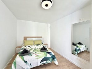 A bedroom with a bed, a nightstand, a mirror, and a ceiling light fixture. - TERRASOL PENTHOUSE DUPLEX PENTHOUSE CENTER TORRE DEL MAR (Torre del Mar)