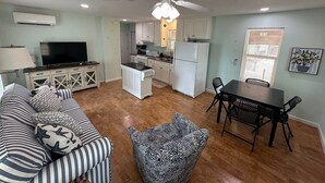 A compact living space with a kitchenette, a dining area, and a seating area with patterned cushions. - Joe's Place- A Hidden Gem by the Bay (Port St Joe)