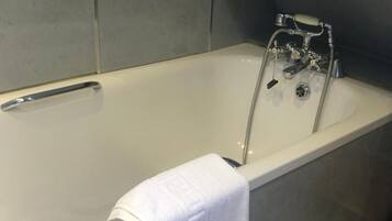 Una vasca da bagno con un rubinetto cromato e un porta asciugamani.