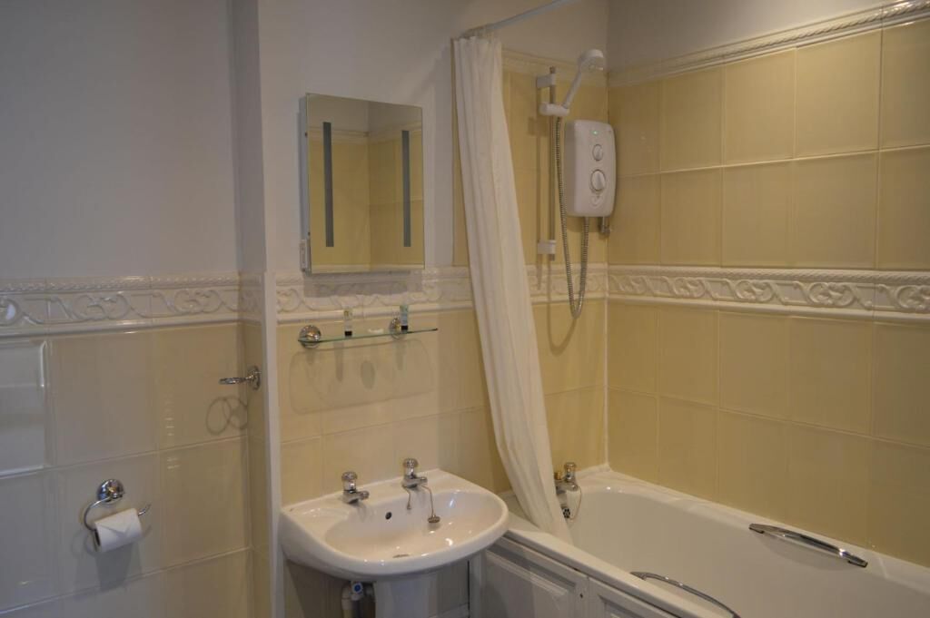 Une salle de bain avec une baignoire, un lavabo, un miroir et une douche.
