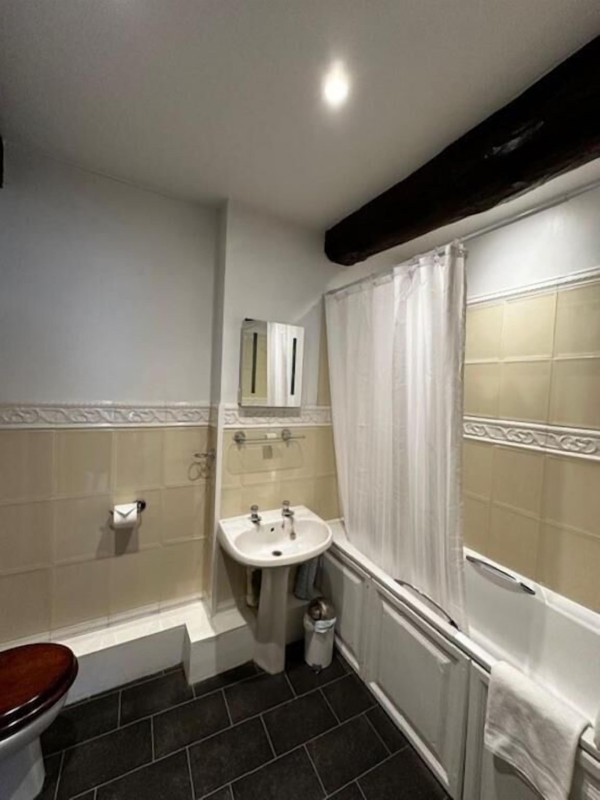 A bathroom with a toilet, sink, and bathtub.