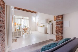 A modern living space with a kitchen, dining area, and a sofa with patterned cushions. - Antica Tipografia in Lucca (Lucca)
