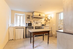 A kitchen with a stove, microwave, and hanging utensils. - 7BR Tuscan Oasis with Pool_Borgo sulla Visona (Capannori)