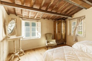 A bedroom with a wooden ceiling, a window with curtains, a chair, and a bed. - 7BR Tuscan Oasis with Pool_Borgo sulla Visona (Capannori)