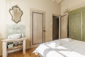 A bedroom with a bed, a dresser, a mirror, and a door. - 7BR Tuscan Oasis with Pool_Borgo sulla Visona (Capannori)