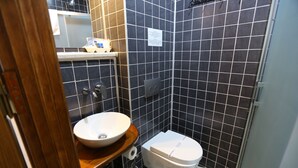 A bathroom with a sink, toilet, and a mirror. - Kidalyo Hotel (Ayvalik)
