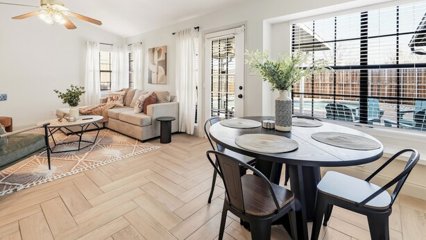 A modern living room with a sofa, coffee table, dining table, and chairs. - Berrywood Stay / Pool + Fire Pit + Foosball (Garland)