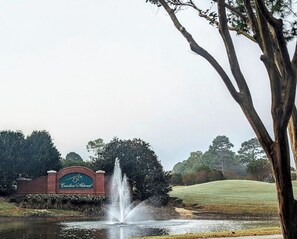 A fountain, a sign for Carolina National, and a grassy area. - Coastal Comfort Near the Best of Brunswick County (Bolivia)