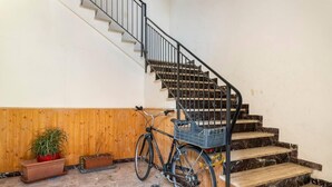 Una escalera con una bicicleta y plantas en macetas.