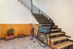 A staircase with a bicycle and potted plants. - Three Bedroom Apartment (Montecatini Terme)