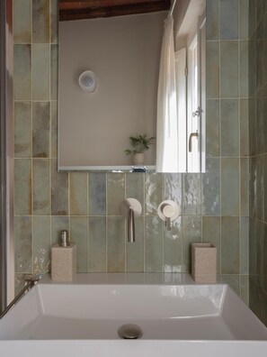 Ein Badezimmer mit einer weißen Badewanne, einer Wandtoilette und einer Duschkabine.