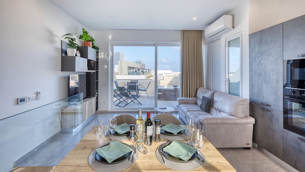A modern kitchen with a dining area, a sofa, and a view of the city. - Luxury duplex apartment, sun terrace, jacuzzi SDIN1-1 (Swieqi)