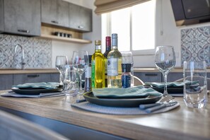 A kitchen counter with wine bottles, glasses, and plates. - Luxury duplex apartment, sun terrace, jacuzzi SDIN1-1 (Swieqi)