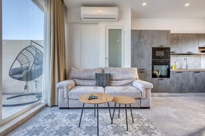 A modern living room with a sofa, two side tables, a chair, and a large window. - Luxury duplex apartment, sun terrace, jacuzzi SDIN1-1 (Swieqi)