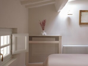 A room with a white radiator, a white cabinet, and a white wall. - One Bedroom Apartment (Lucca)