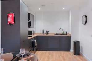 A modern kitchen with a built-in oven, a coffee maker, and a sink. - City Point Aberdeen by Guestz (Aberdeen)