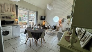 A compact living space with a kitchen, dining area, and a large window. - Charming gîte near the Côte Viticole (Chevigny-en-Valière)