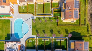 Ein Luftbild einer Wohngegend mit Schwimmbad, Solaranlage und gepflegtem Rasen.