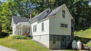 A two-story white house with a porch and a small attached garage.