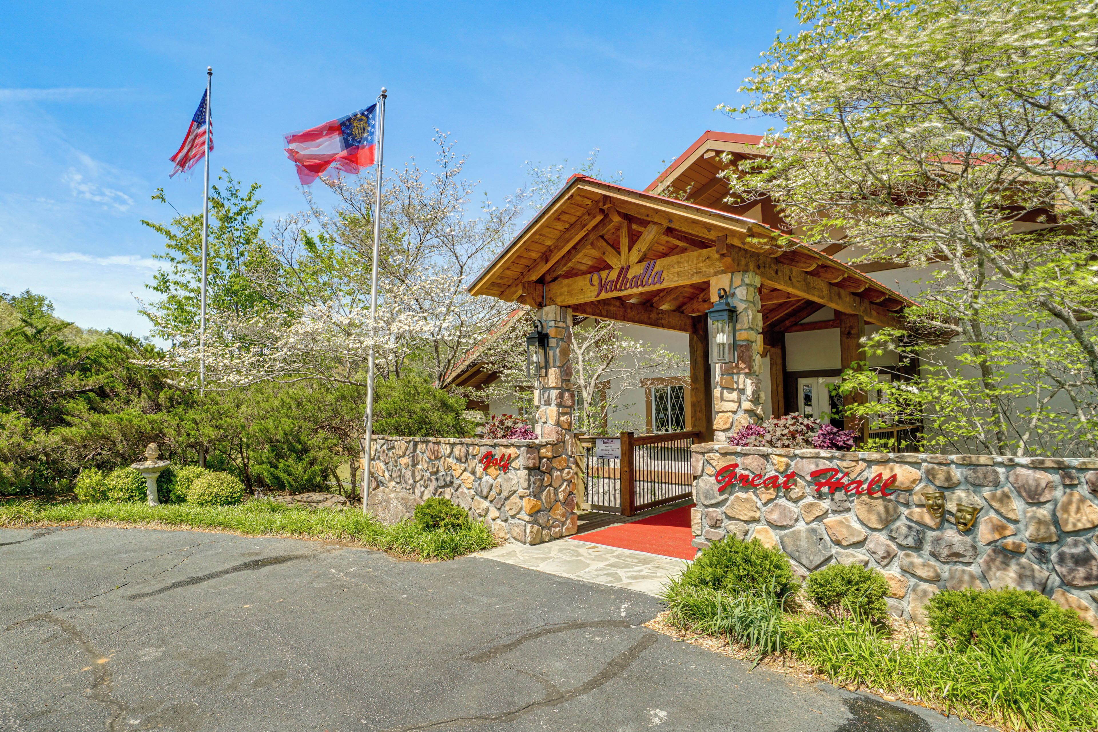 A stone-walled building with a wooden porch and a red carpet entrance.