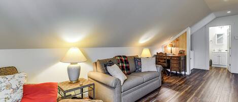 A cozy living room with a sofa, a small table, and a lamp.