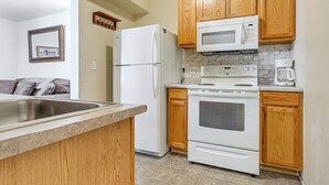 A kitchen with wooden cabinets, a refrigerator, a microwave, an oven, and a coffee maker. - Near Oregon Caves: 2-studio Retreat w/ Game Room! (Cave Junction)